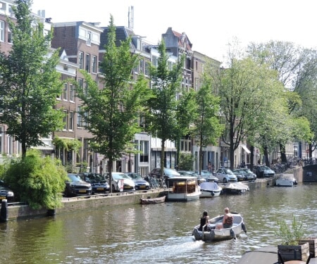 Deux personnes naviguant en bateau sur un canal à Amsterdam.